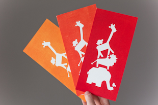 drie kaartjes in verschillende kleuren, rood, oranje en licht oranje met een olifant, giraf en een leeuw