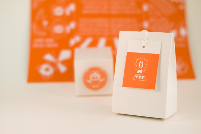 Een oranje label op een doosje voor een geboortekaartje