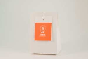 een doosje geboortesuiker met een oranje label